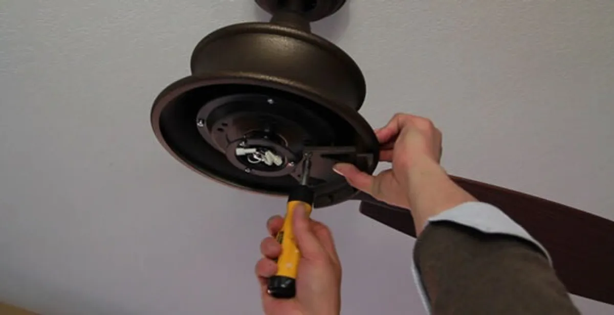 Electrician installing ceiling fan mounting bracket and fixture in Bradenton, FL